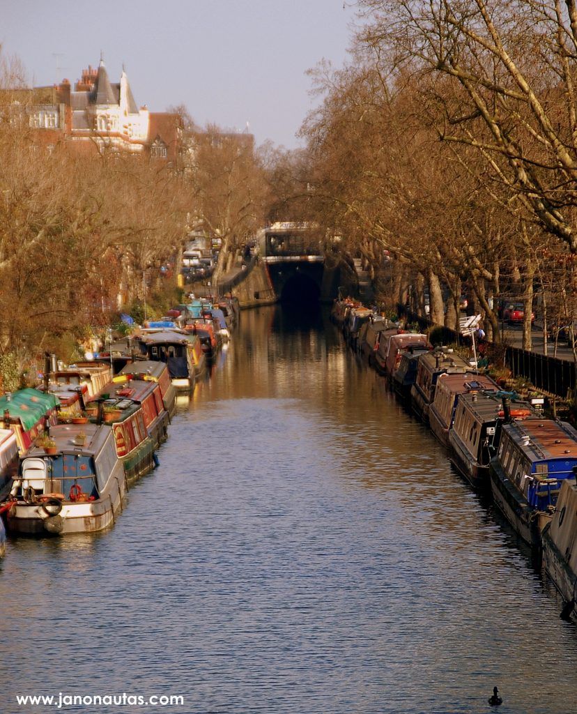 Uno de los canales navegables de Londres Vista del canal navegable en Little Venice, Londres, con barcos amarrados a ambos lados y vegetación alrededor.
