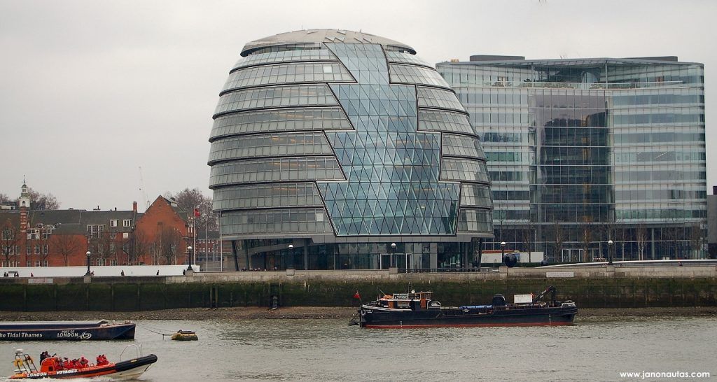 City Hall Vista del moderno edificio de la City Hall de Londres, con su estructura ovalada de hierro y vidrio, situado junto al río Támesis bajo un cielo nublado.