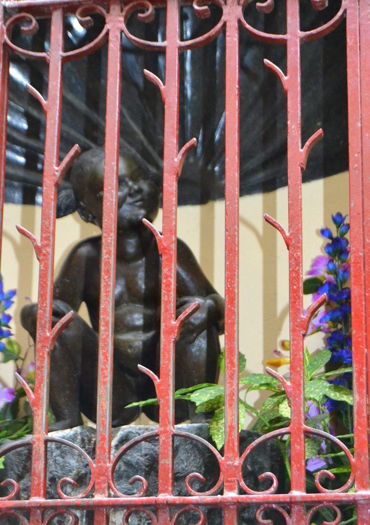 La figura de la Jeanneke Pis tras la verja Los tres gamberros de Bruselas